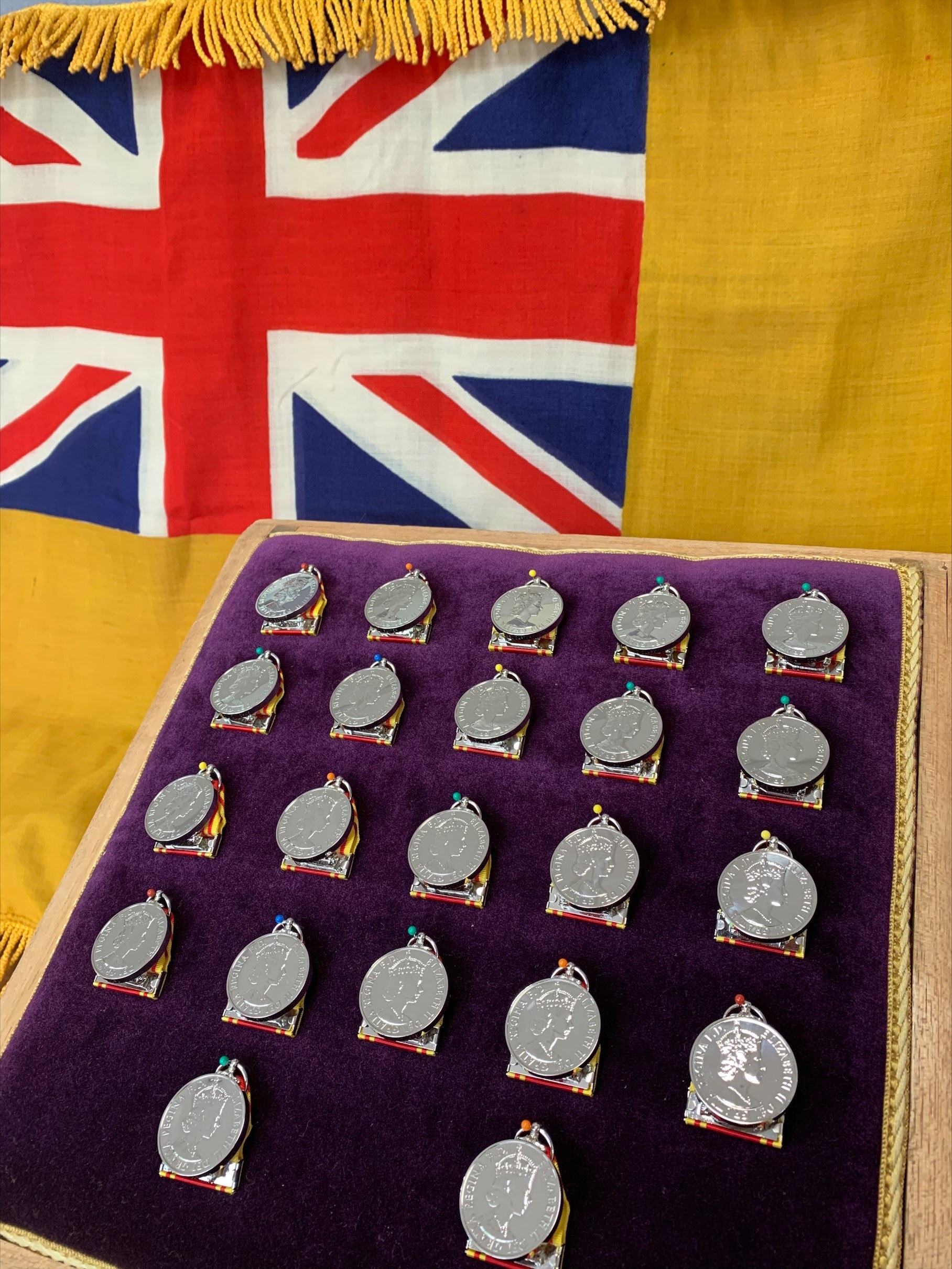 A photo of 20 year medals on a purple cushion and a Union Jack Flag.