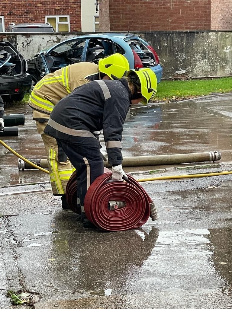 National firefighter tests rolling up hose